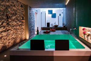 łazienka z zieloną wanną i dwoma krzesłami w obiekcie BeB Sekeles Suites and Spa w Katanii
