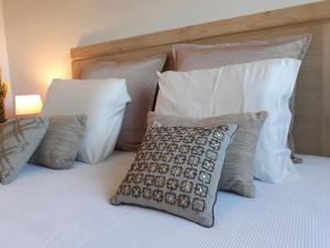 uma cama com almofadas brancas e uma almofada em Casa das Olaias & closed parking em Lisboa