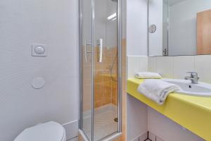 La salle de bains est pourvue d'une douche et d'un lavabo. dans l'établissement B&B HOTEL Pau Lescar, à Lescar