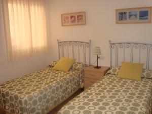 カルボネラスにあるApartamentos Sotavento Carbonerasのベッドルーム1室(隣り合わせのベッド2台付)