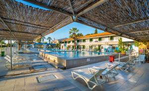 a swimming pool with chairs and a resort at Sifne Thermal Otel in Çeşme