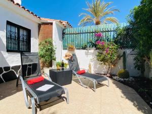 a patio with two chairs and a fence at Bungalow Los Porches by SunHousesCanarias in Maspalomas