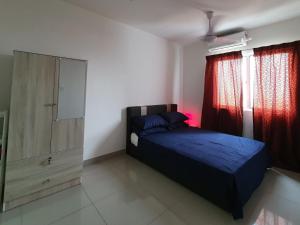 Apartment Servis UITM Puncak Alam في Bandar Puncak Alam: غرفة نوم بسرير وخزانة وستائر حمراء