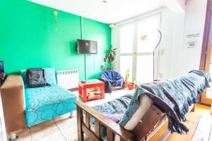 un soggiorno con pareti verdi e divano di Bla Guest House a El Calafate
