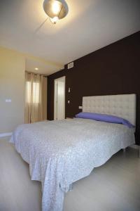 a bedroom with a white bed with a blue pillow at Livingtarifa Apartamento Entre Dos Aguas in Tarifa