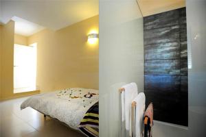 a bedroom with a bed in the corner of a room at Livingtarifa Apartamento Entre Dos Aguas in Tarifa +29 photos