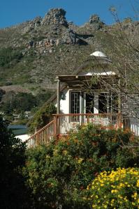 ein Haus mit einer Veranda mit einem Berg im Hintergrund in der Unterkunft Kairos Lodge in Hout Bay