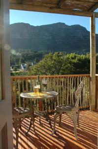 a patio with a table and chairs on a deck at Kairos Lodge in Hout Bay