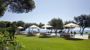 a row of benches with umbrellas next to a pool at Can Simoneta - Adults Only in Canyamel