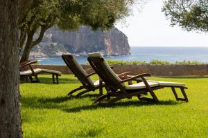 trois chaises longues assises dans l'herbe près de l'océan dans l'établissement Can Simoneta - Adults Only, à Canyamel