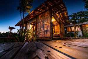 a bamboo house at night with a wooden floor at Bahia Soul - Flow Beach House - Taipu de Fora - Península de Maraú in Barra Grande