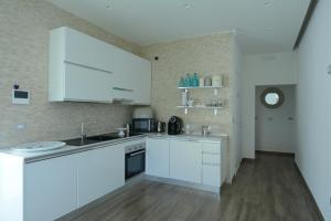 a white kitchen with white cabinets and a sink at La Casa di Frank in San Ferdinando di Puglia