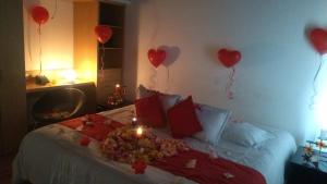 a bed with red hearts on the wall and balloons at Hotel TuKasa Inn in Bogotá