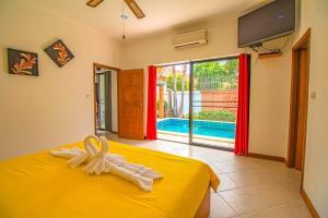ein Schlafzimmer mit einem gelben Bett und einer Glasschiebetür in der Unterkunft VIEW TALAY VILLAs POOL 155, JOMTIEN BEACH, PATTAYA in Jomtien Beach