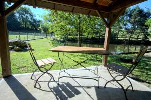 un tavolo e due sedie seduti sotto un gazebo di Le Petit Lac a Bourganeuf