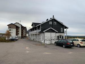 a large building with cars parked in a parking lot at Vaeltajankulma H6 in Ylläsjärvi