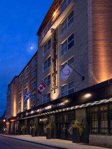 un edificio de hotel con banderas en la parte delantera en Hotel Chateau Laurier Québec, en Quebec