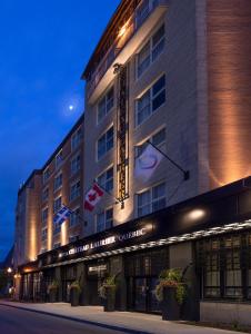 un bâtiment d'hôtel avec des drapeaux à l'avant dans l'établissement Hotel Chateau Laurier Québec, à Québec