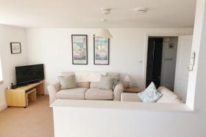 a living room with a couch and a tv at 15 The CLIFF APARTMENT-2 BED- SEA VIEW in Trearddur