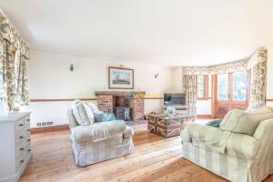 a living room with two chairs and a fireplace at Chestnut Cottage - Stunning Countryside Views! PARKING, 4 BED, 3 BATHROOMS in White Waltham