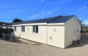 a small white building with a black roof at Ogof Aberporth in Aberporth