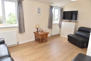 a living room with a couch and a television at Ogof Aberporth in Aberporth