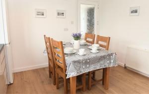 uma mesa de jantar com cadeiras e uma toalha de mesa em Ogof Aberporth em Aberporth