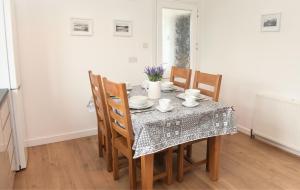 a dining room table with chairs and a table cloth at Ogof Aberporth in Aberporth