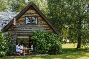 a group of people sitting at a table outside of a cabin at Hunter's Lodge in Padure