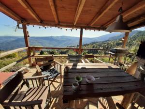 a wooden table and chairs on a deck with a view at Arli House in Ano Trikala