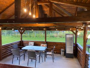 a patio with a table and chairs in a cabin at Casa de vacanta Madalina in Novaci-Străini