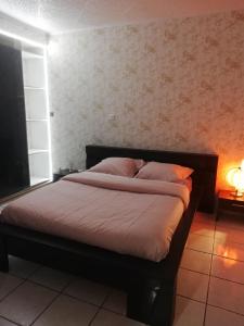 a bed in a bedroom with a wall at Zahra dor in Plombières-lès-Dijon