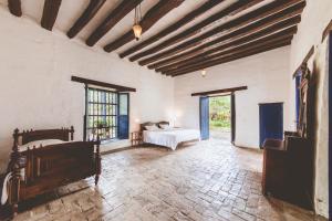 a bedroom with a bed and a room with windows at Hacienda Pisoje in Popayan