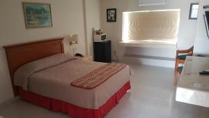 Un dormitorio con una cama grande y una ventana en Hotel y Suites Nader, en Cancún