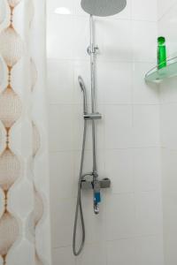 a shower with a shower head in a bathroom at Rohat Hotel in Kokand