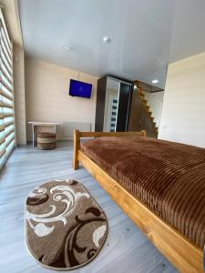 - une chambre avec un grand lit et un tapis dans l'établissement Апартаменти Золота Баня 5, à Skhidnitsa