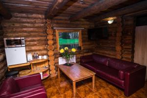 een woonkamer met een bank en een tafel bij Log Cabin in Kuldīga