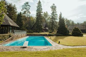 a swimming pool in the yard of a house at Log Cabin in Kuldīga