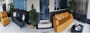 a living room with couches and plants in a building at Hotel Sweet Home in Bogotá