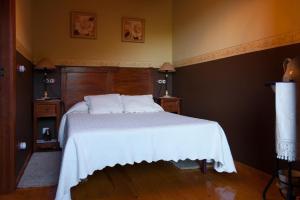 a bedroom with a bed with a white bedspread at Casa Lolo de Villaviciosa in Camoca