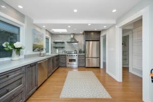 a large kitchen with wooden cabinets and a counter top at The Oxbow House - Designer 3BD/2BA Home in Napa