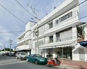 um edifício branco com carros estacionados em frente em Hotel Grand Caribe em San Andrés