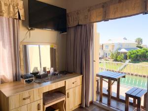 a kitchen with a large window with a view of the water at Marina Martinique B&B in Jeffreys Bay