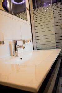 een witte wastafel in een badkamer met een spiegel bij Krugs Haus Ferienwohnungen Ebersburg in Ebersburg