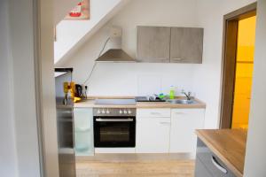 a kitchen with white cabinets and a stove top oven at Krugs Haus Ferienwohnungen Ebersburg in Ebersburg