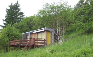 a small house on a hill in a field at Tiny House mit Klima und Heizung, in idyllischer Ortsrandlage in Iba