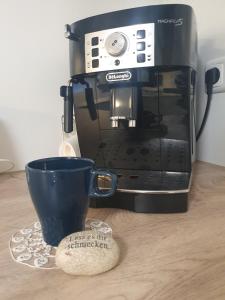 a black coffee maker and a cup on a table at Gemütlich ruhig und zentral durch Bahnhof in Bordesholm