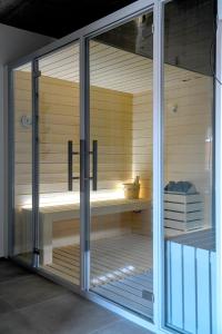 una sauna con puertas correderas de cristal en una habitación en O Cantinho dos Cabrais, en Inguias