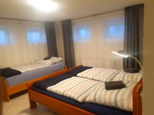 two beds in a room with two windows at Gemütlich ruhig und zentral durch Bahnhof in Bordesholm