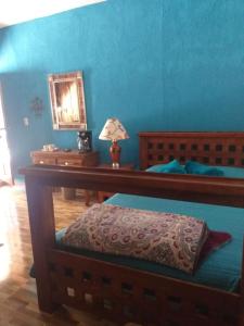 una camera da letto con pareti blu, un letto e uno specchio di Hotel Huasca Terrazza a Huasca de Ocampo